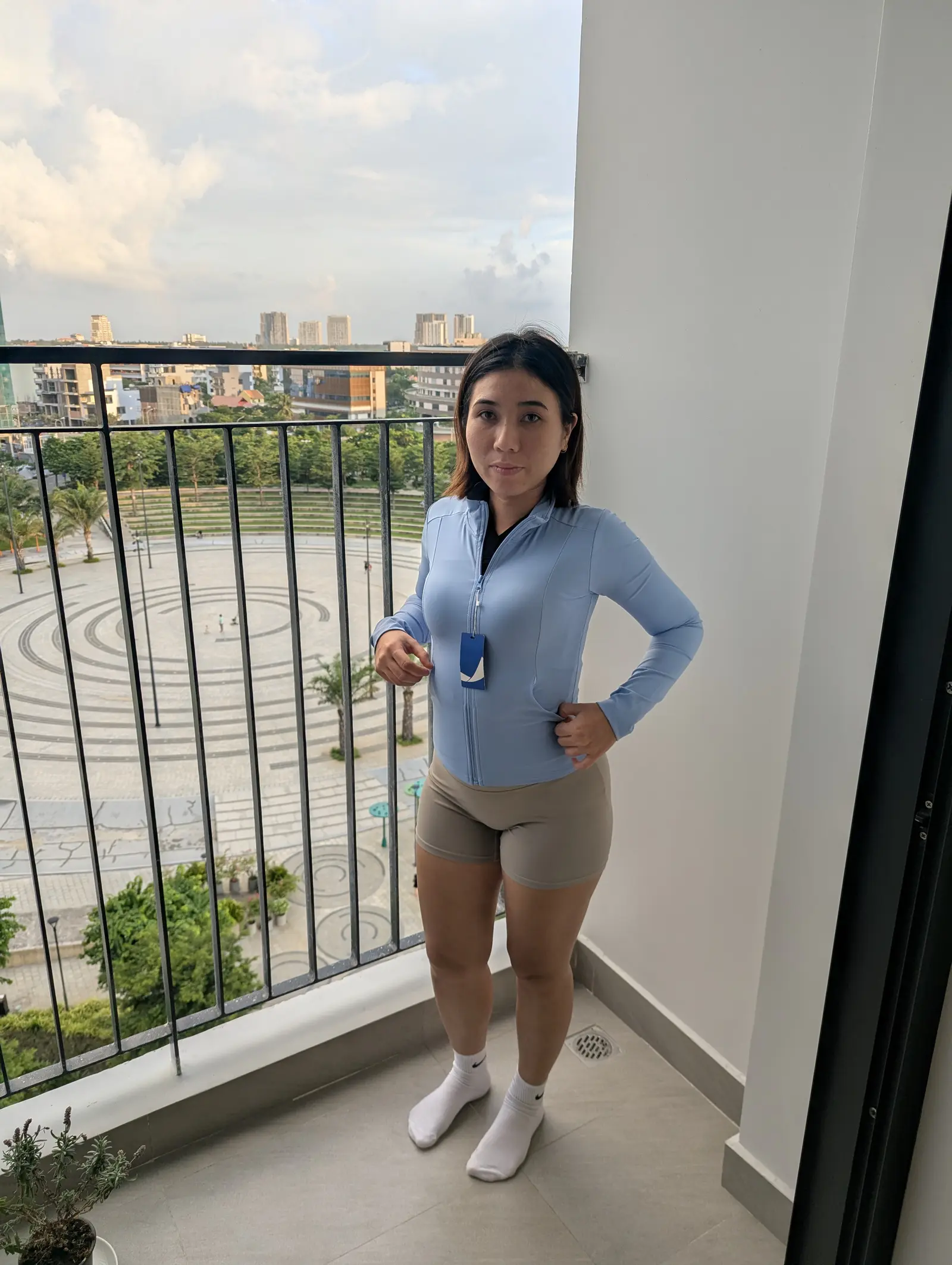 Baby blue zip jacket worn with beige biker shorts, full length