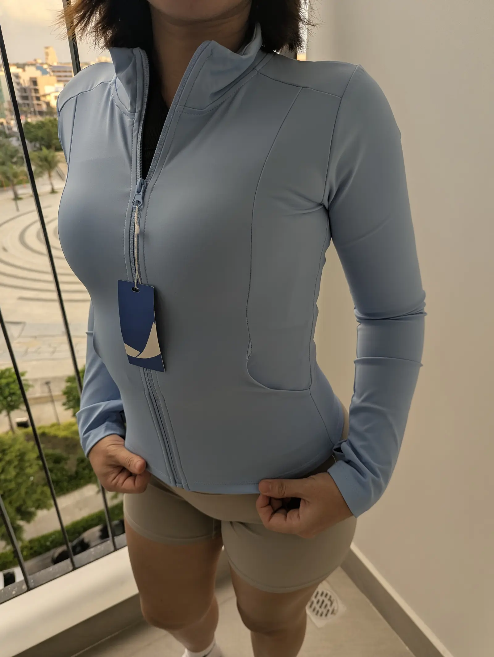 Close-up of the zip, stand collar and seams of the baby blue jacket